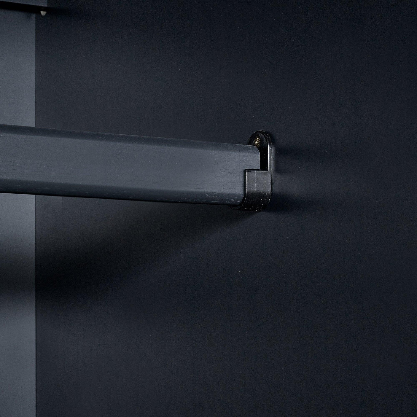Anthracite wardrobe hanging rail close-up with dark wooden interior detail