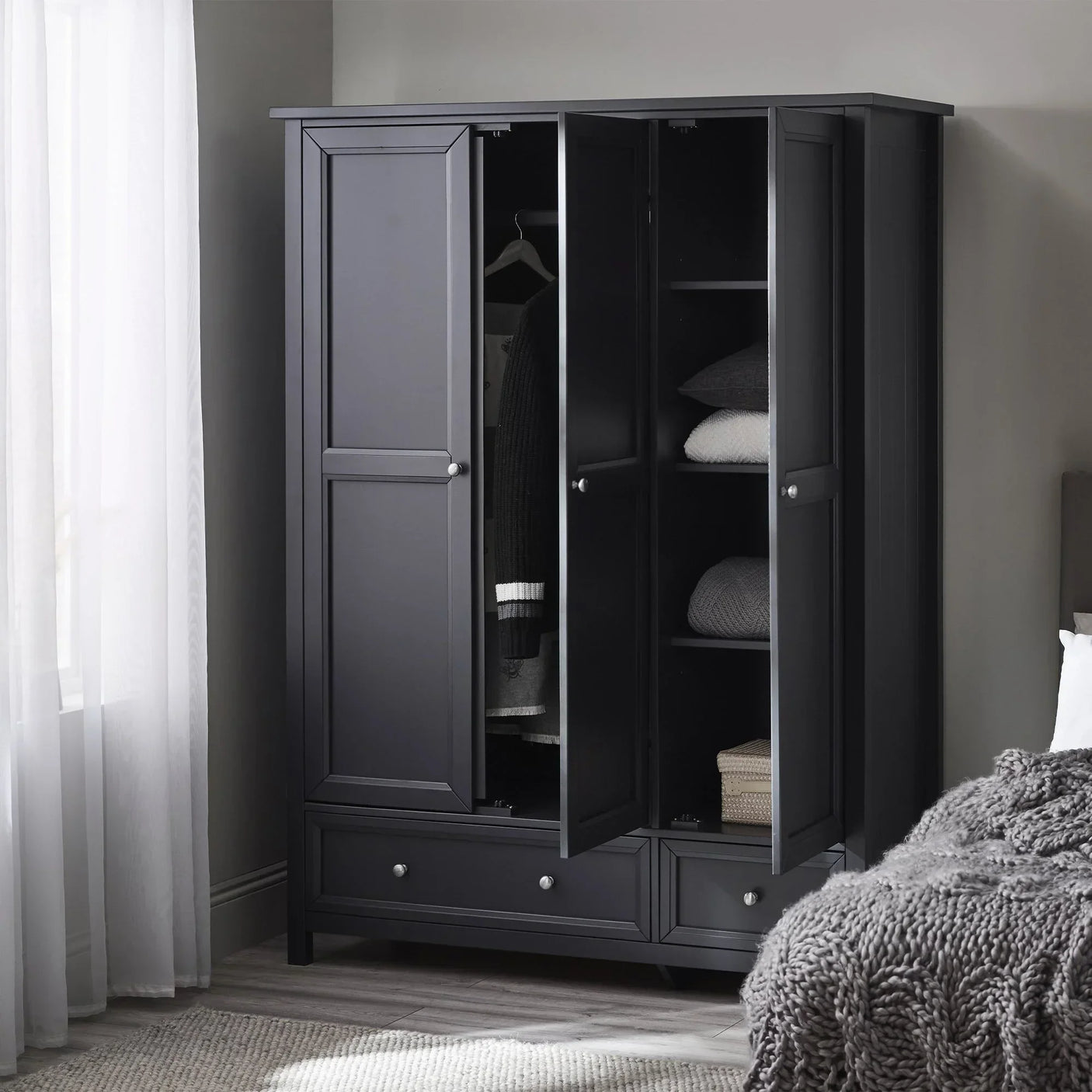 Anthracite three door wardrobe with shelves and drawers in modern bedroom setting