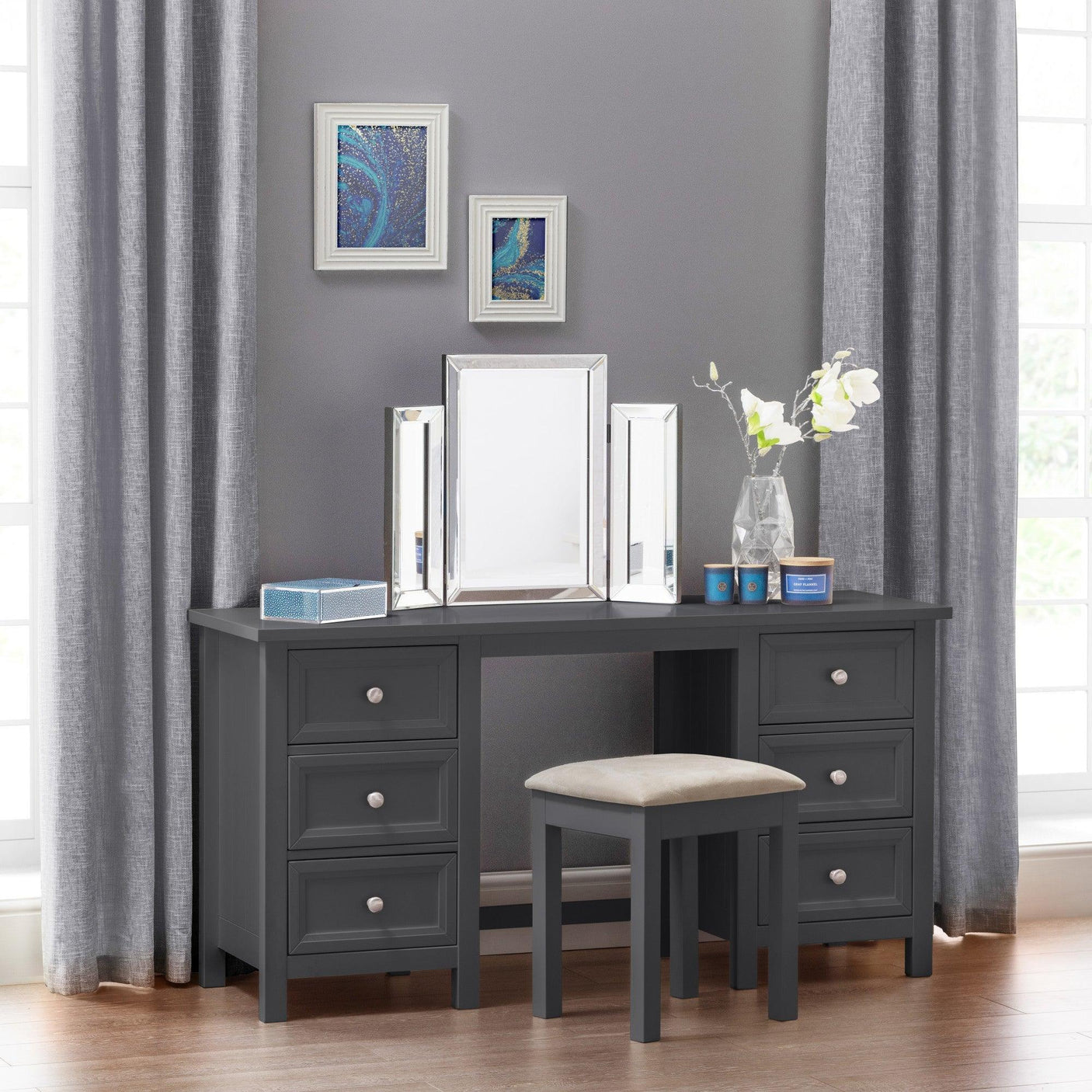 Grey dressing table with six drawers, trifold mirror and stool, styled with flowers