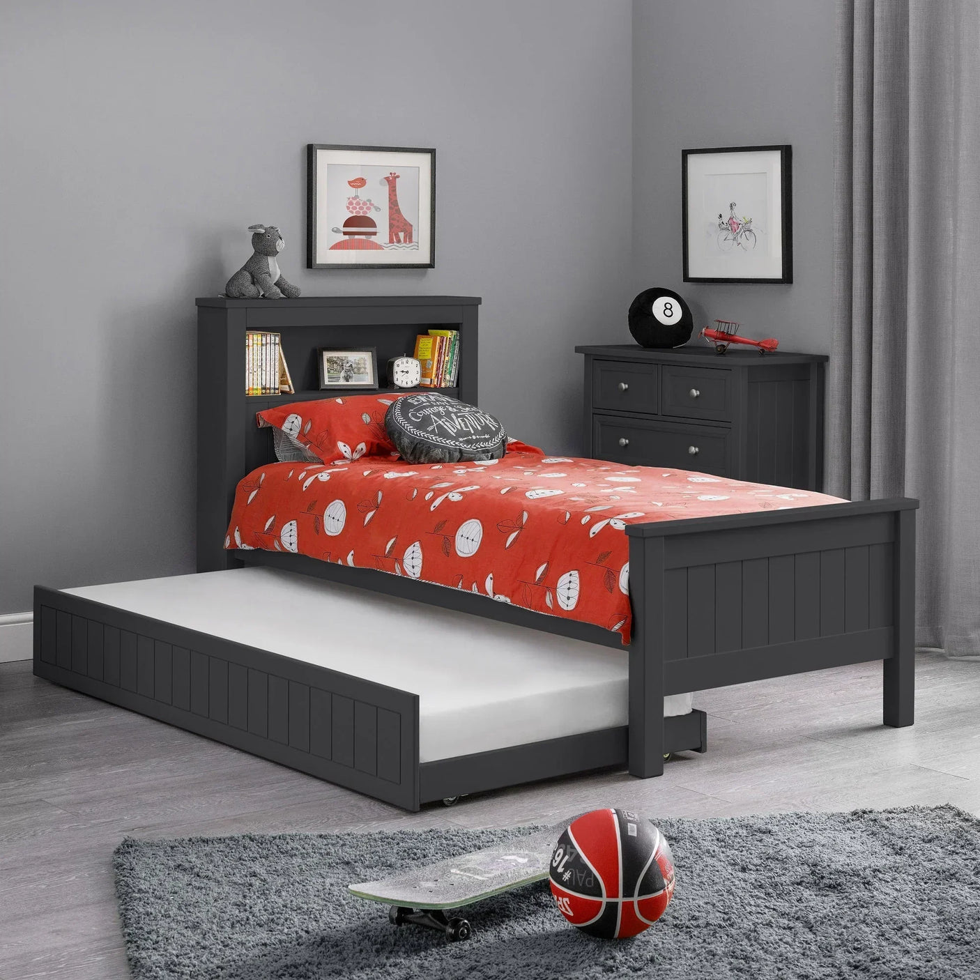 Anthracite bookcase bed with trundle drawer in children’s bedroom, red bedding, grey decor