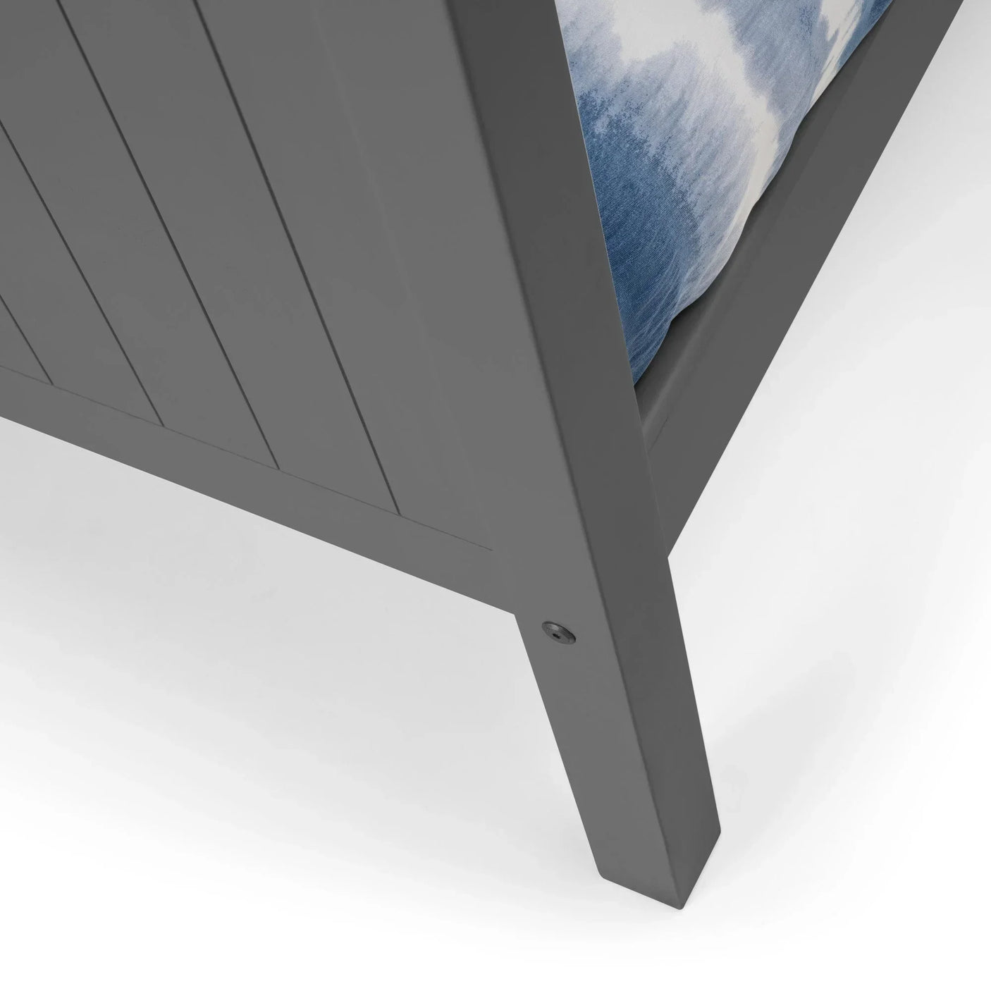 Grey wooden bed frame corner with vertical panel detailing and partial view of blue mattress