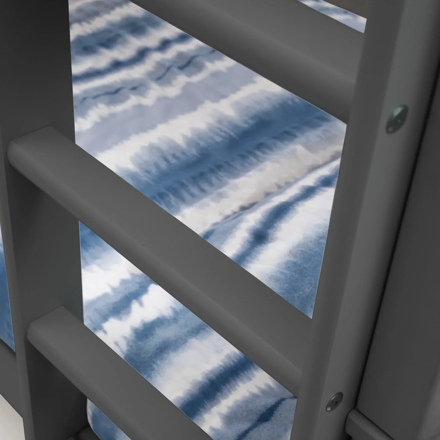 Closeup of grey bunk bed ladder and blue striped mattress