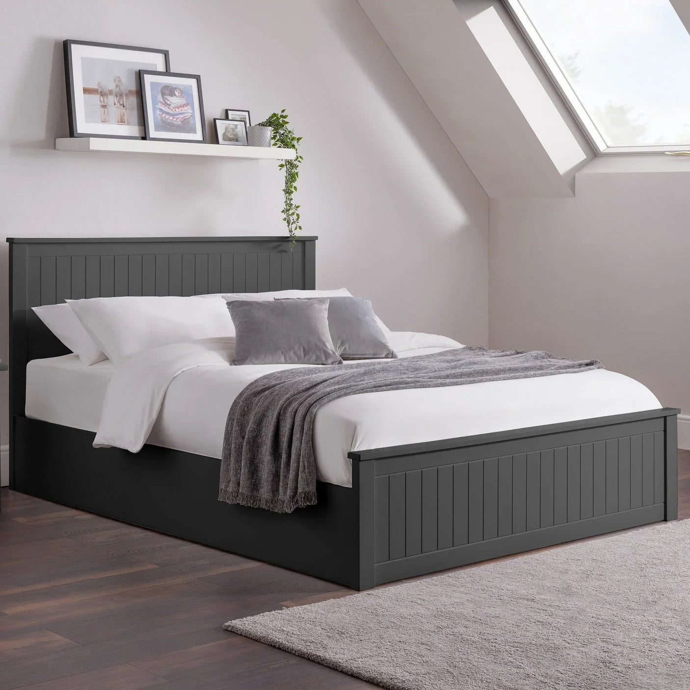Dark grey wooden bed frame with panelled headboard, layered bedding and pillows