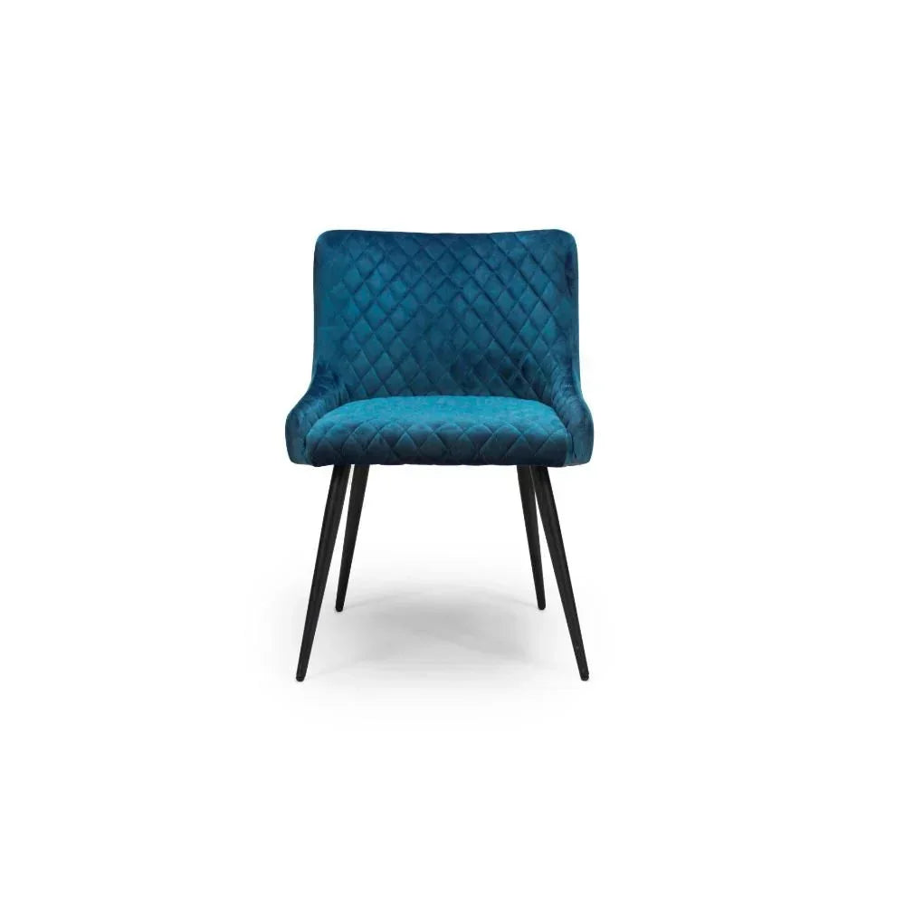 Blue velvet dining chair with diamond stitching and black tapered legs, front view