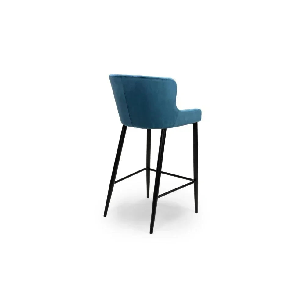 Blue velvet bar stool with black legs shown from the rear angle