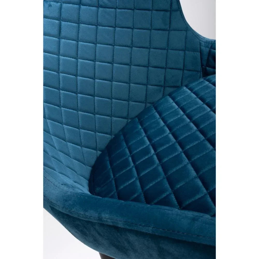 Close up of blue velvet accent chair with quilted diamond stitching on seat and backrest