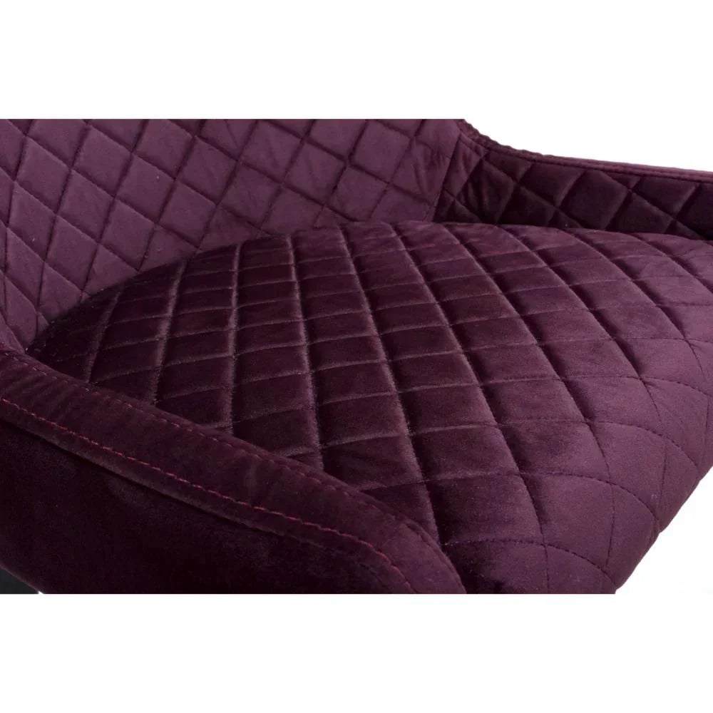 Closeup of purple velvet armchair with quilted diamond pattern upholstery