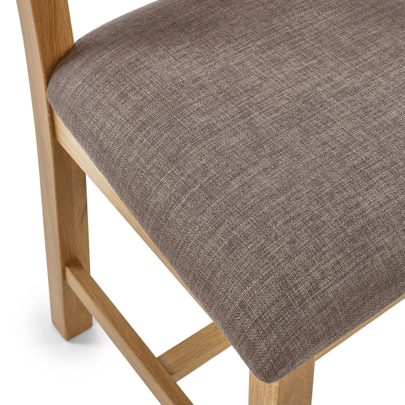 Close-up of neutral fabric dining chair seat with light wood legs