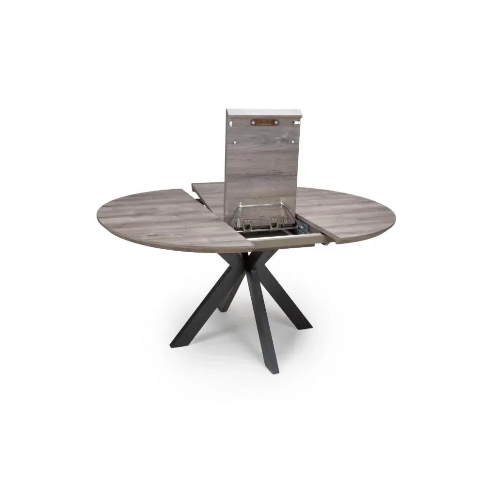Round extending dining table with grey wood top and black cross legs, extension leaf raised