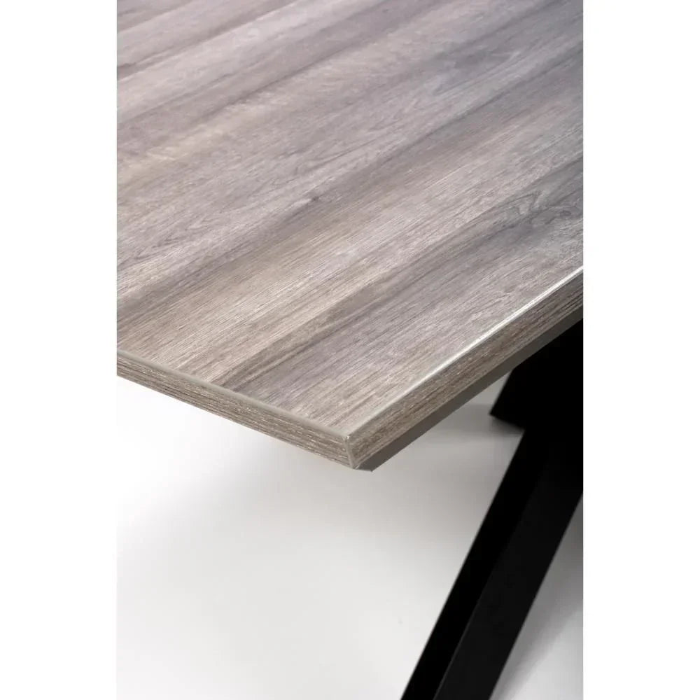 Close-up of grey wood dining table top with angled black metal legs
