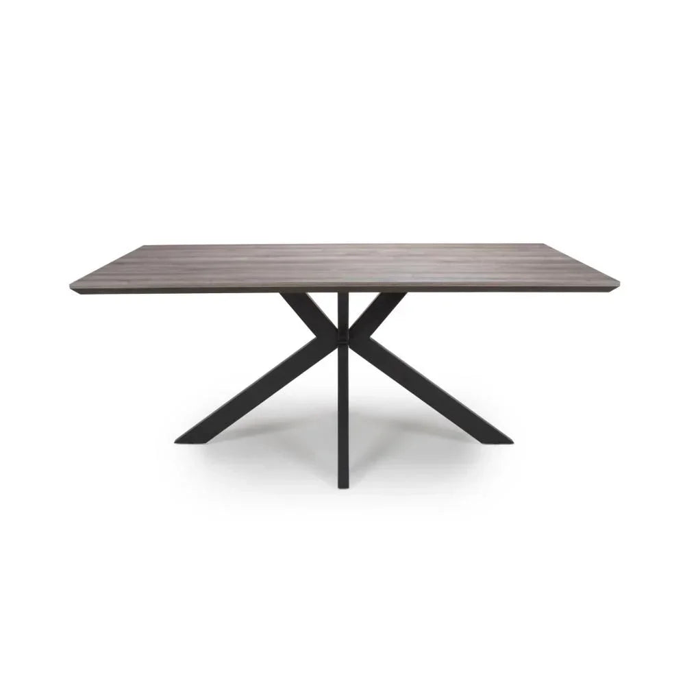 Rectangular dining table with wood grain top and black metal cross legs on white background