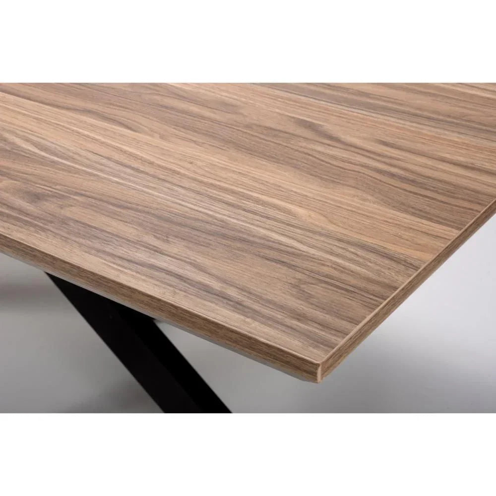 Closeup of wooden dining table top with natural wood grain and angled metal legs