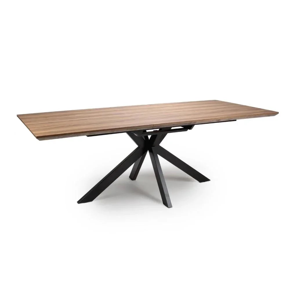 Rectangular wooden dining table with black metal star-shaped legs on white background