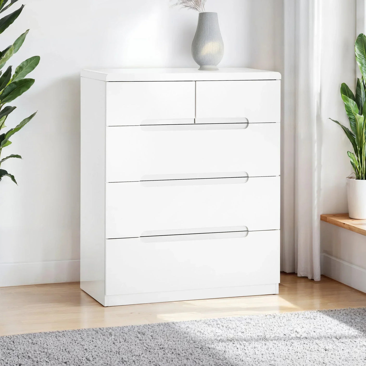 White chest of drawers with four large drawers and two small top drawers in a bright room