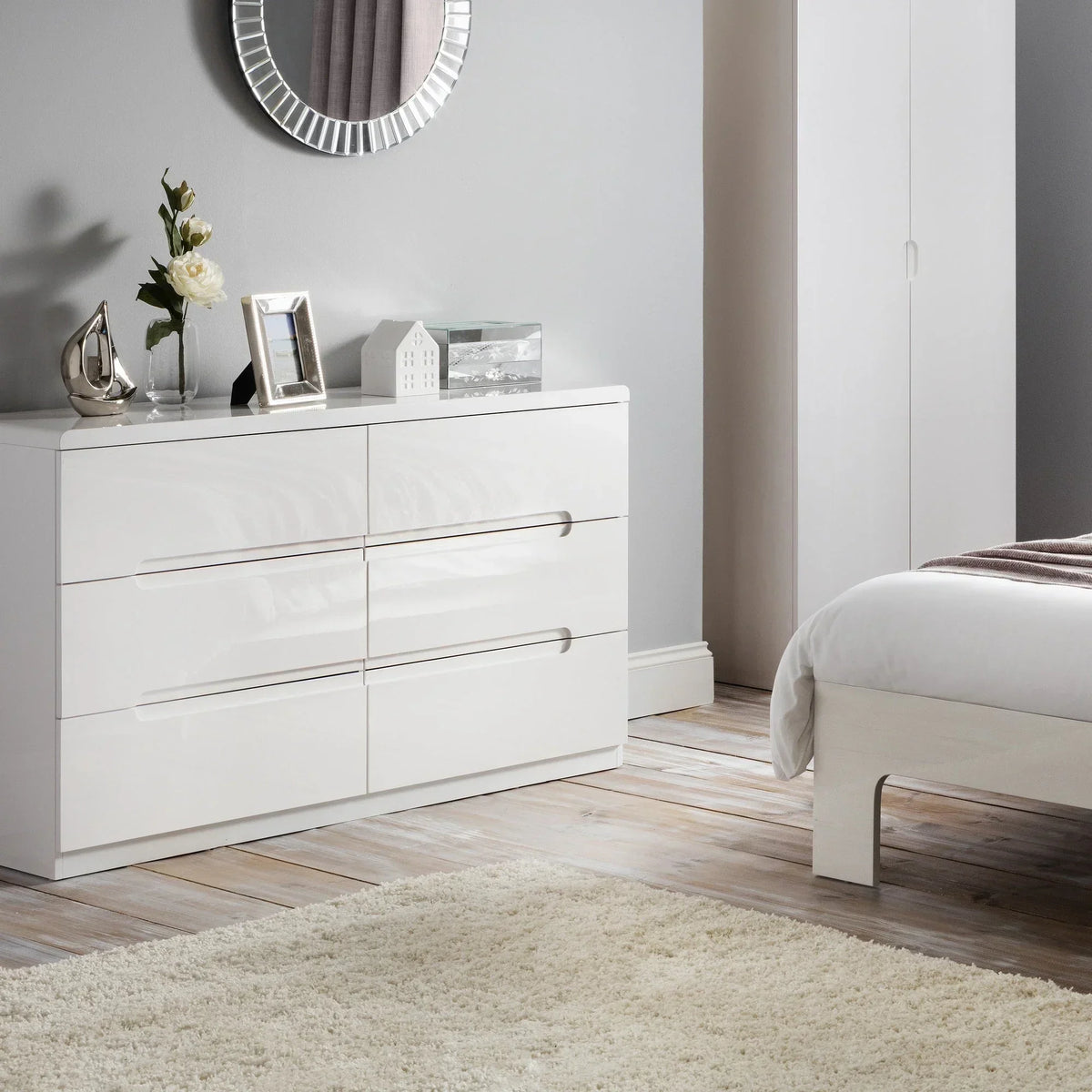 White six drawer chest with gloss finish in a modern bedroom setting