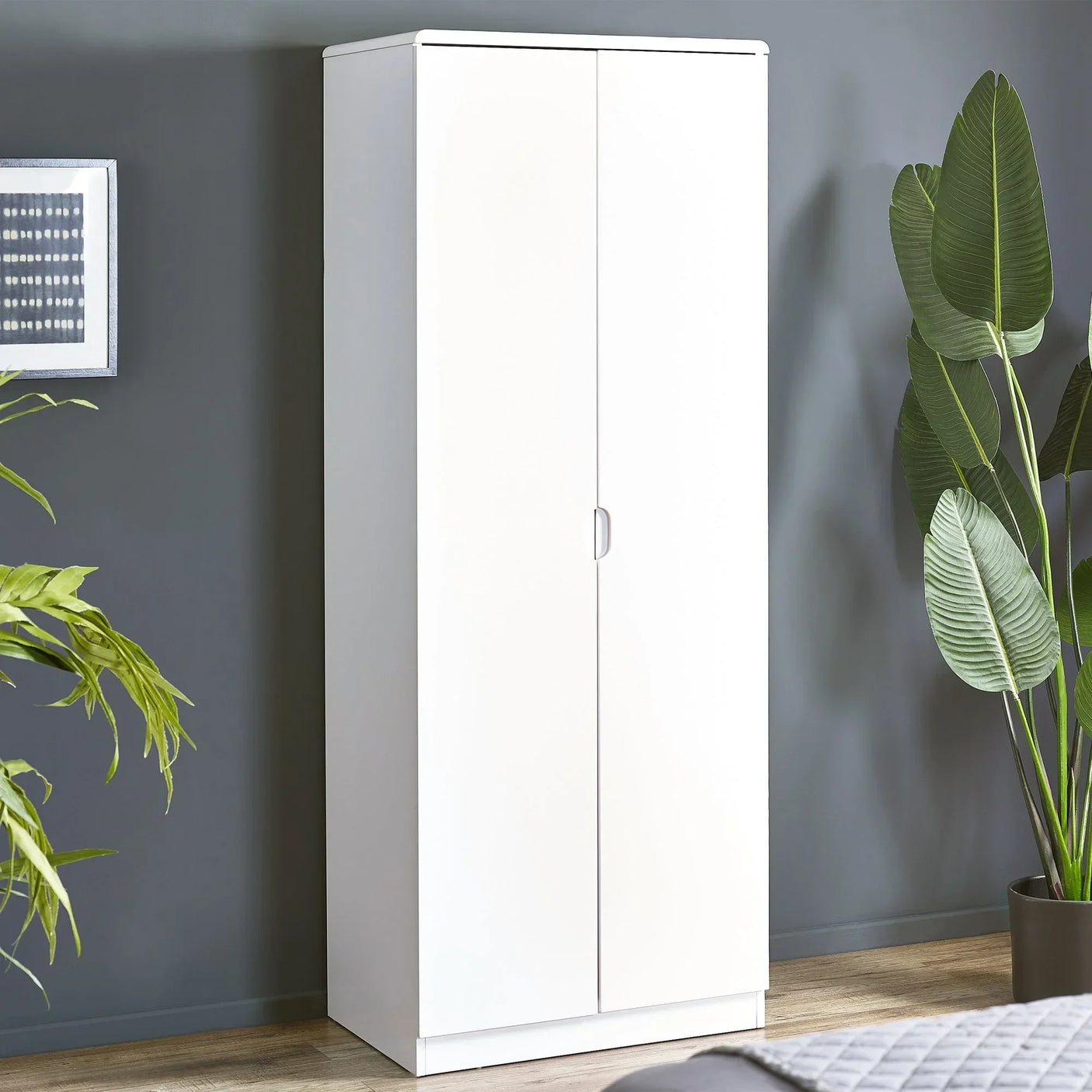 White 2 door wardrobe with handle in modern bedroom, placed against grey wall and plants