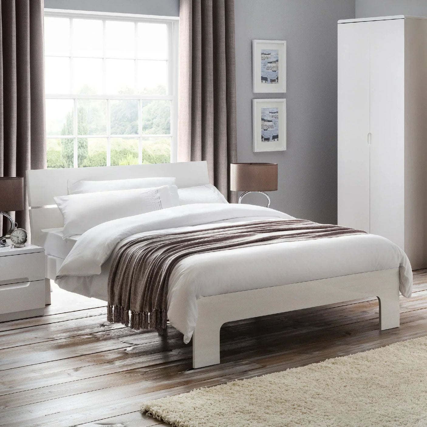 White double bed with wooden frame in modern bedroom, layered bedding and brown throw blanket