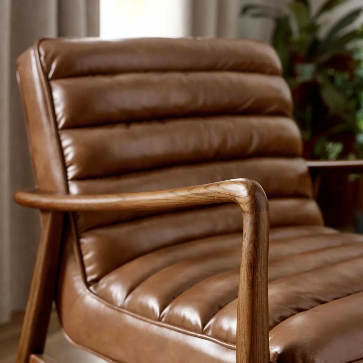 Brown leather accent chair with wooden armrest and ribbed seat detail