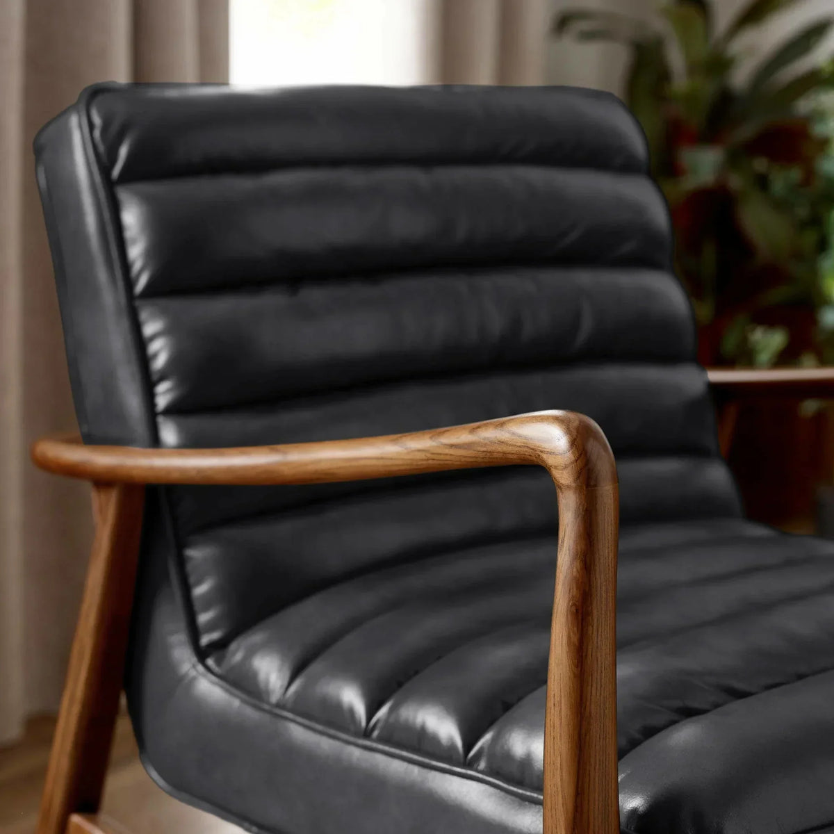 Black leather accent chair with wooden armrest and ribbed cushioning in living room