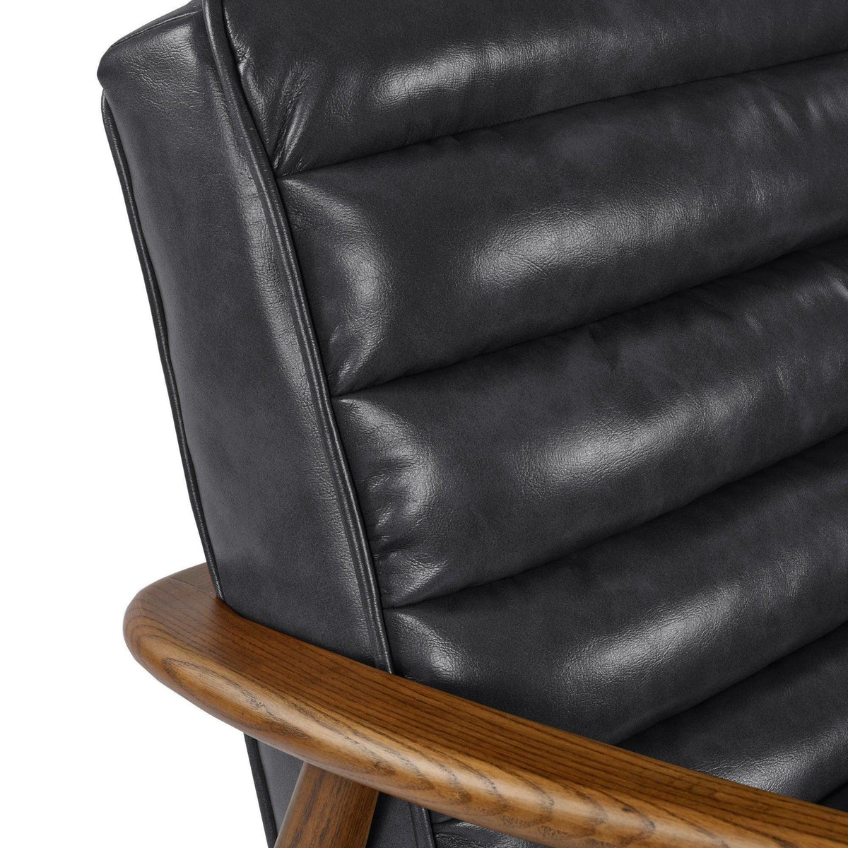 Closeup of black leather armchair with ribbed backrest and wooden arm detail