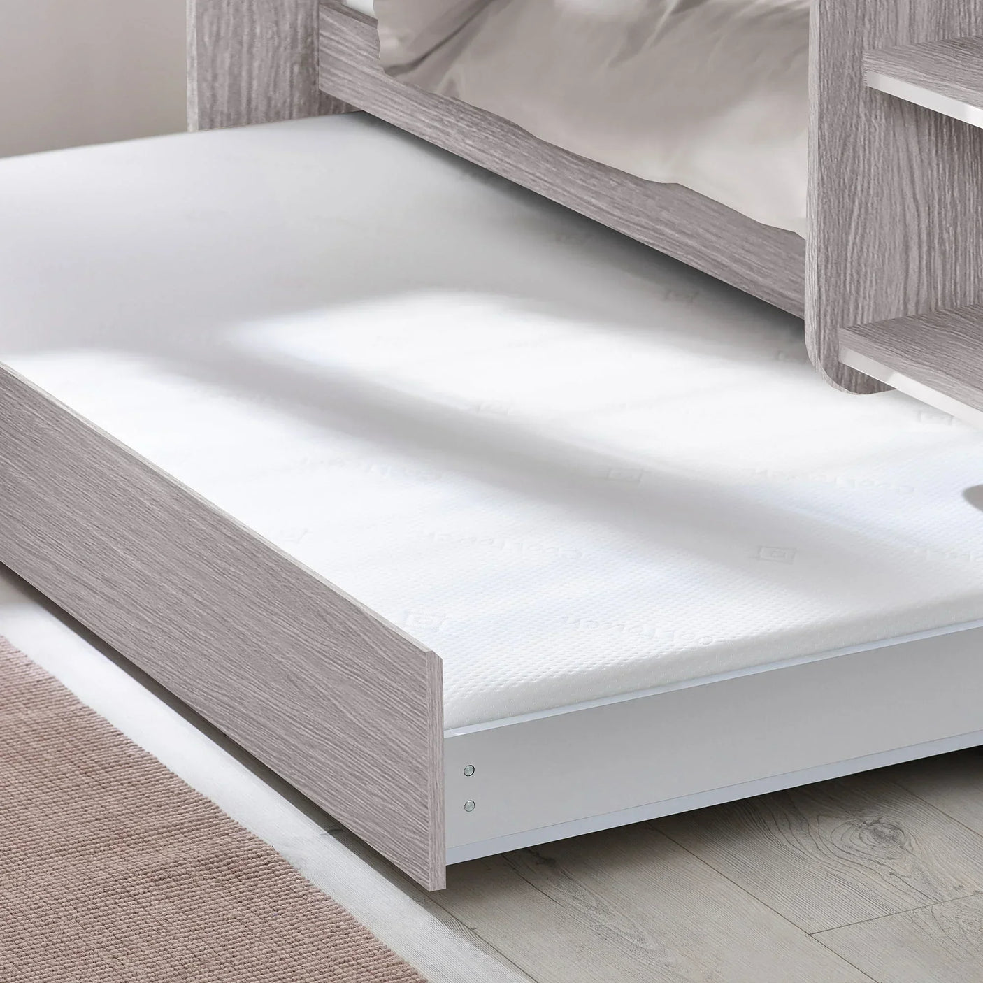 Grey oak underbed storage detail with mattress and shelving on wood floor