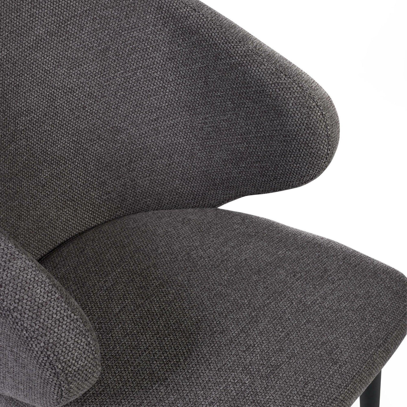 Close-up of grey fabric dining chair with curved backrest and cushioned seat