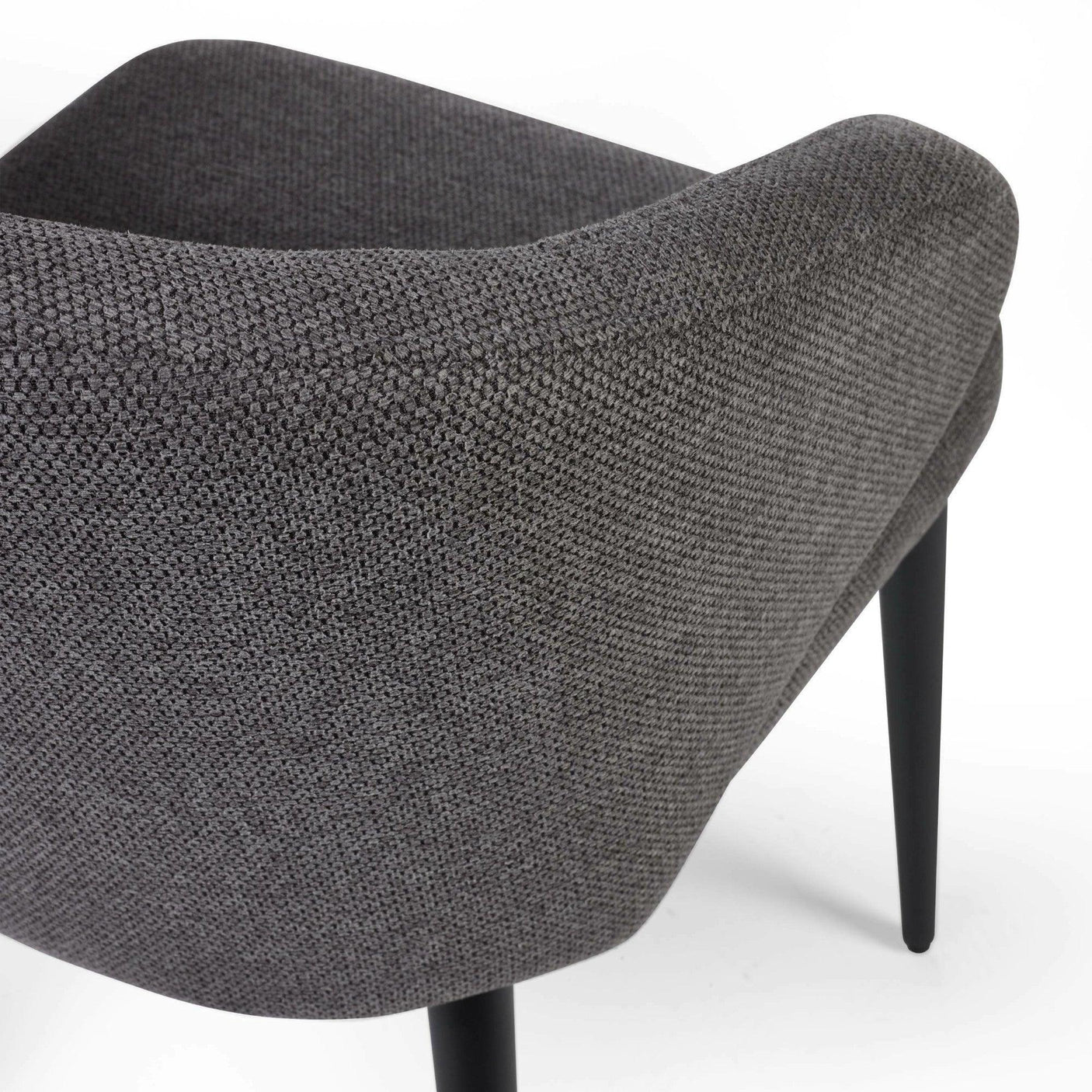 Close-up of grey fabric dining chair with curved backrest and black tapered legs