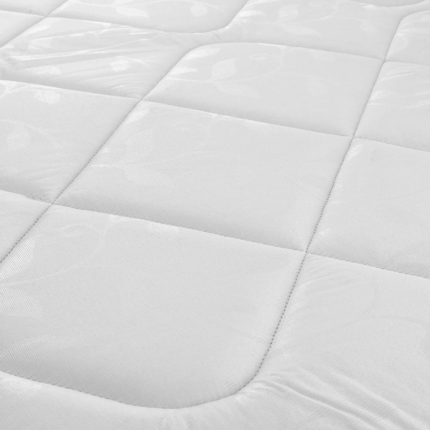 Close-up of white mattress surface showing stitched quilted pattern and soft fabric texture