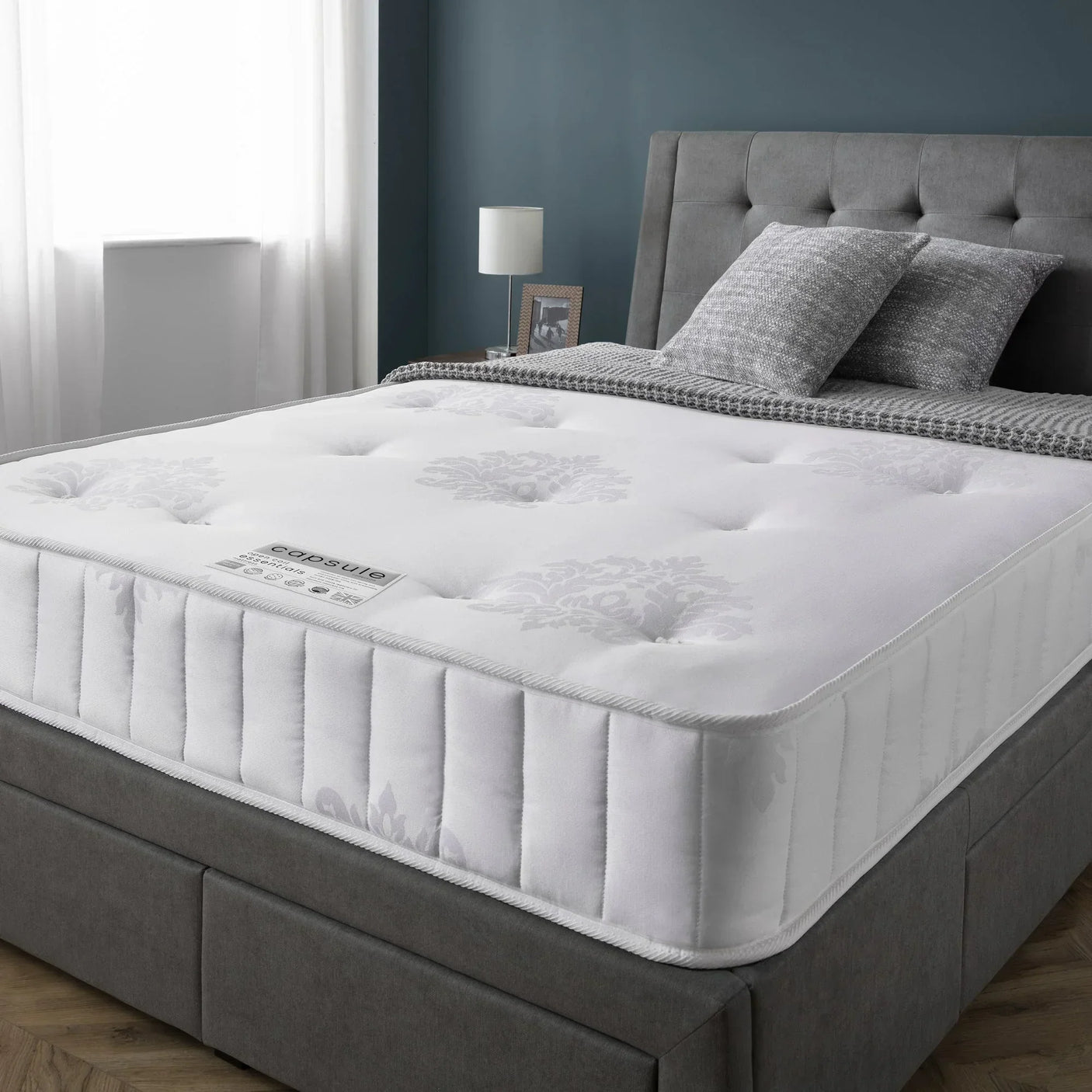 Capsule Essentials 90cm mattress on grey upholstered bed in modern bedroom setting