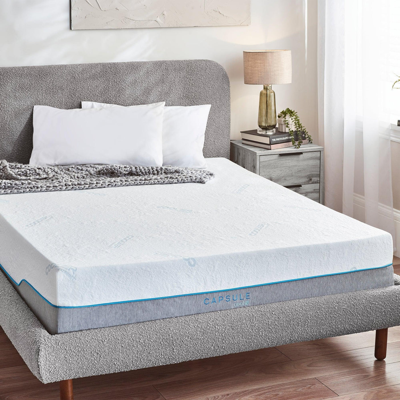 Capsule Cool mattress 150cm on grey upholstered bed with white pillows and grey throw