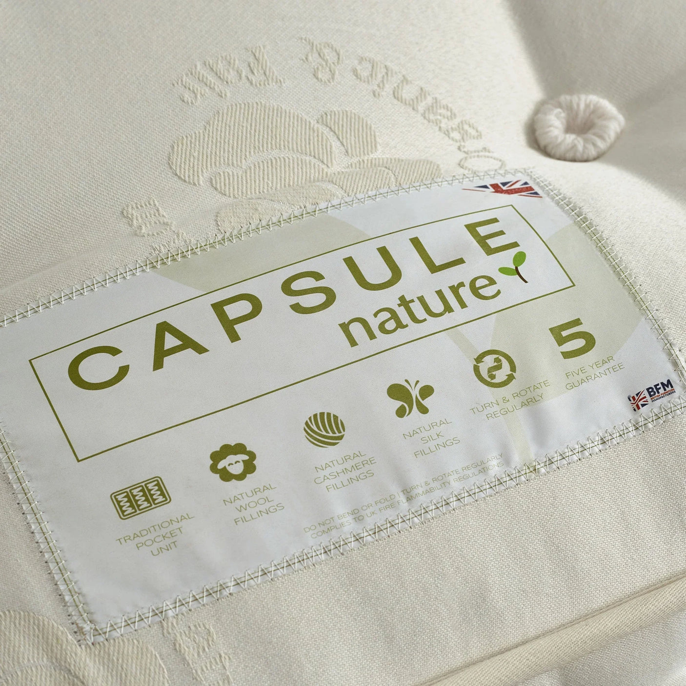 Capsule Nature mattress label showing natural wool and cashmere fillings, cream fabric close-up