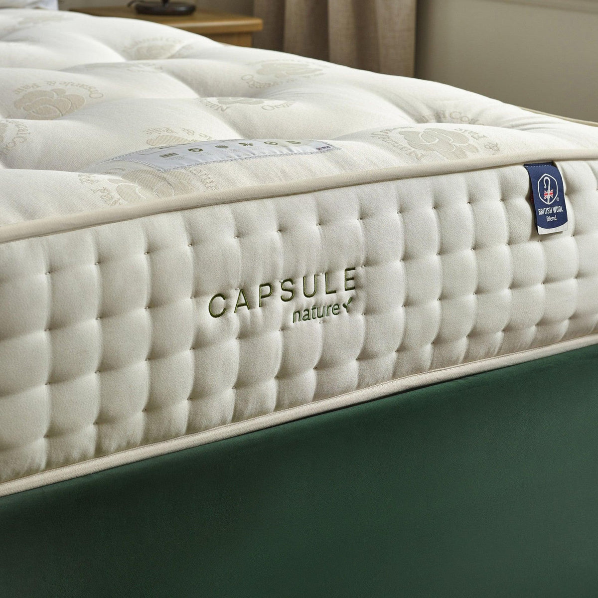Cream tufted mattress with button detailing and wool-blend label, close-up