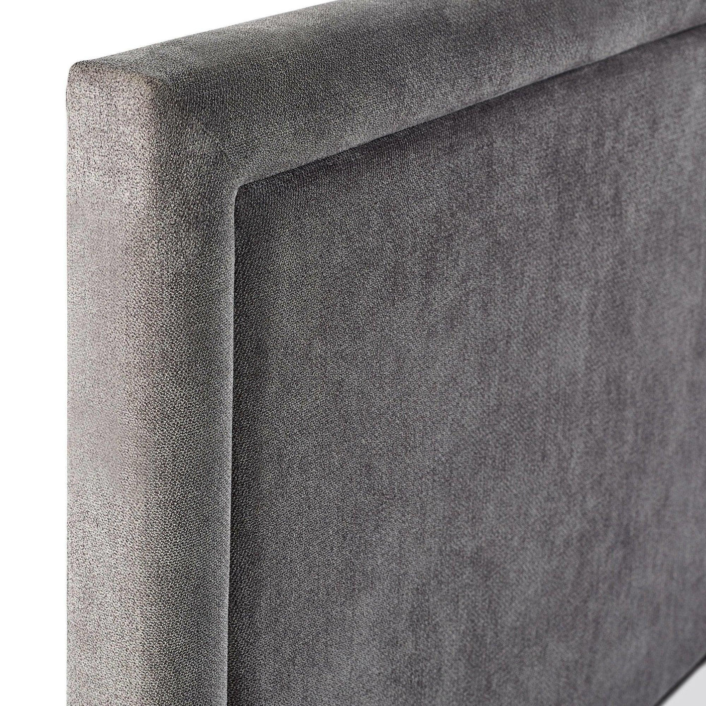 Close-up of grey fabric bed headboard with smooth texture and modern design