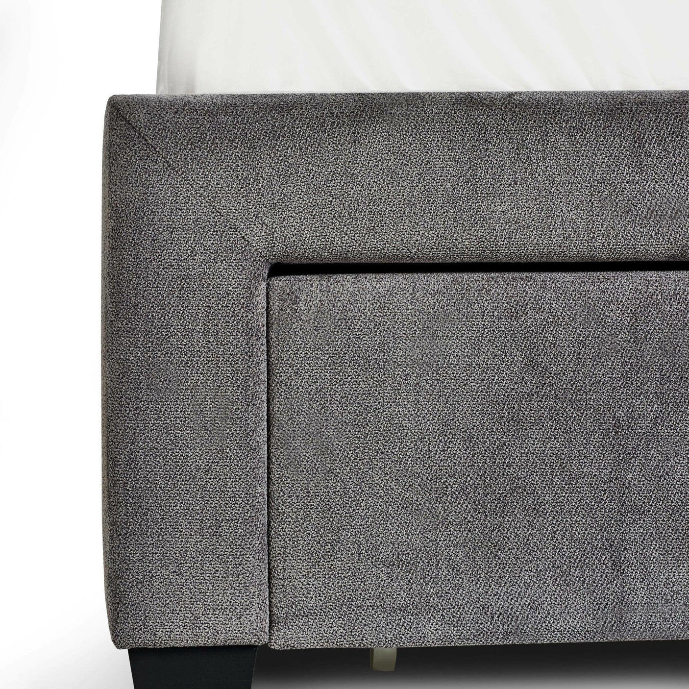 Grey upholstered bed frame with textured fabric and black leg corner detail