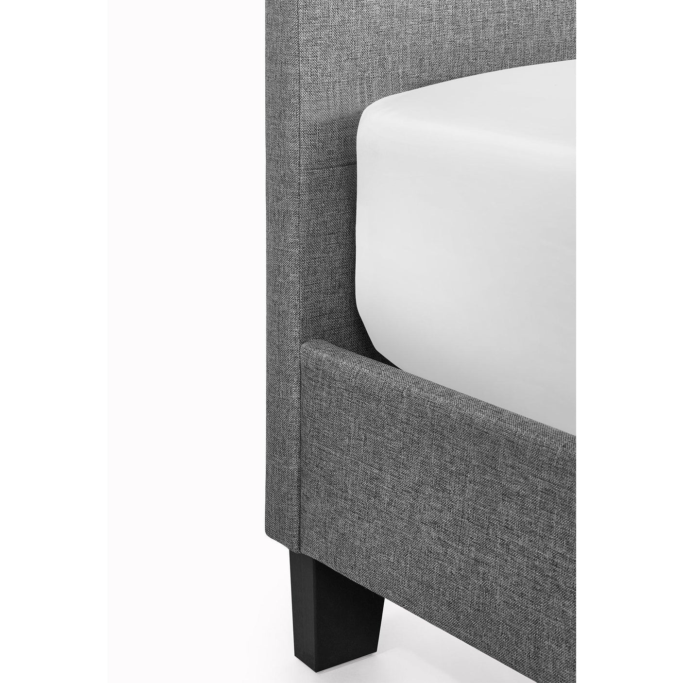 Close-up of grey fabric bed frame corner with black wooden leg and white mattress