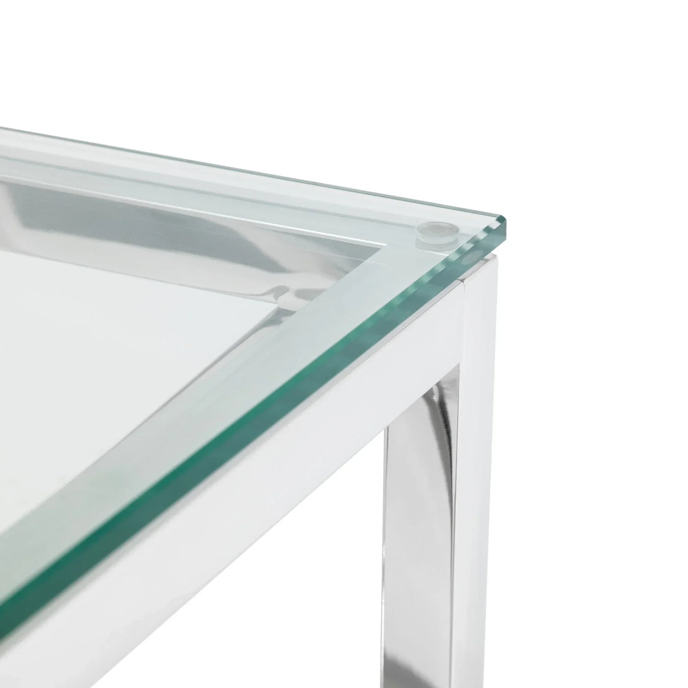 Clear glass coffee table corner with polished chrome metal frame, close-up view