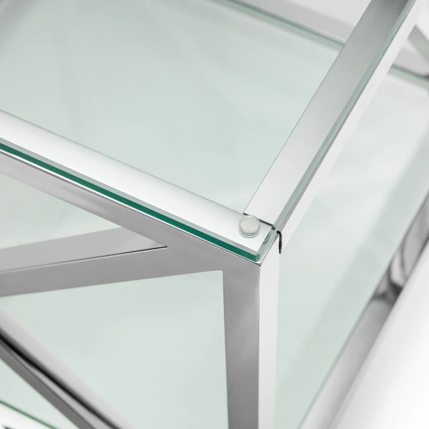 Glass coffee table with chrome metal frame close-up on corner and edge detail