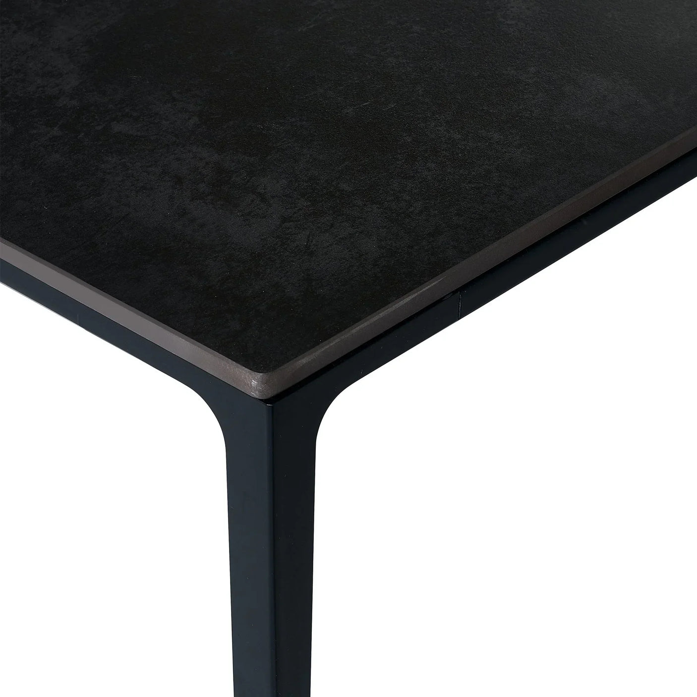 Close-up of black stone top dining table with metal leg and rectangular edge detail