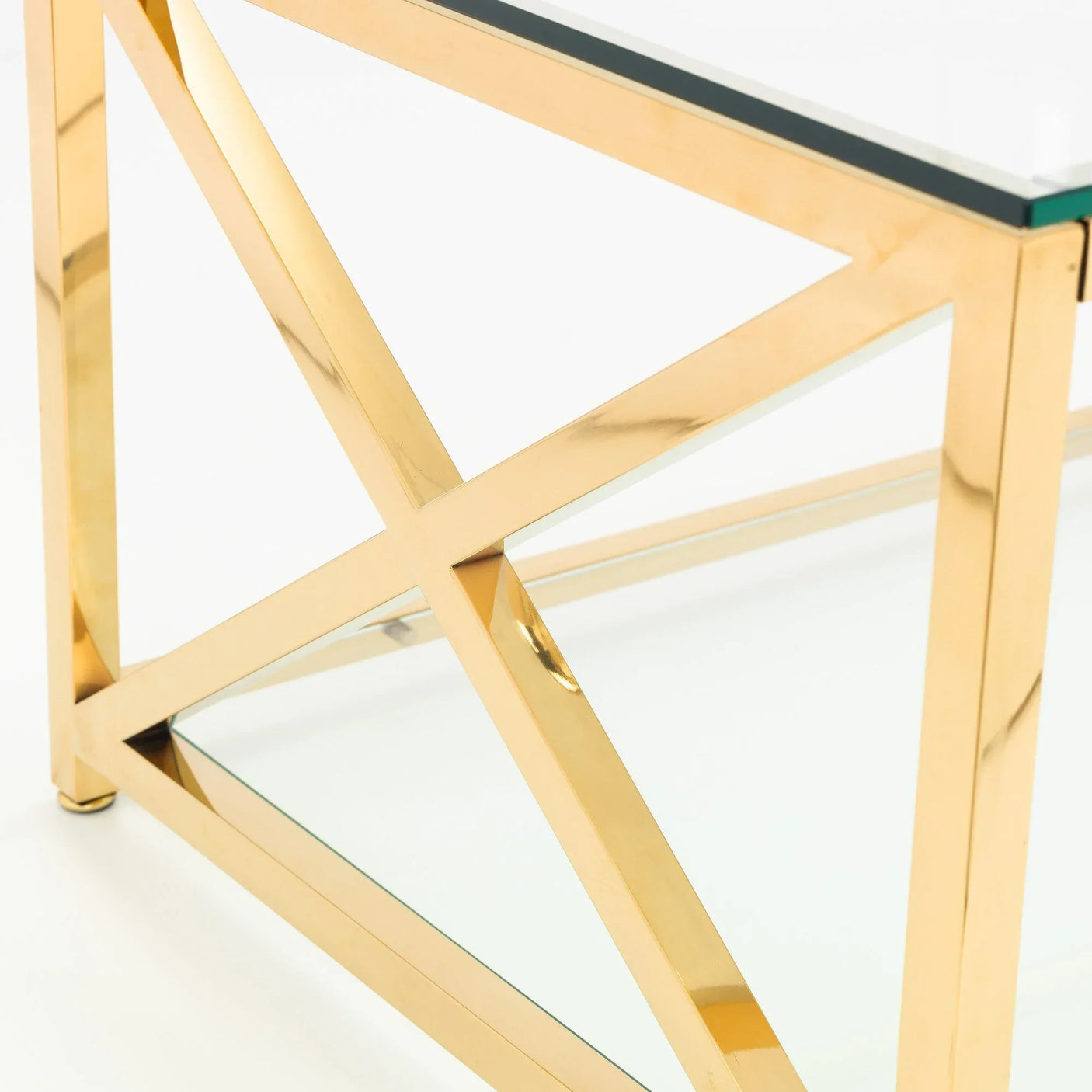 Gold metal coffee table frame with clear glass top and geometric side design