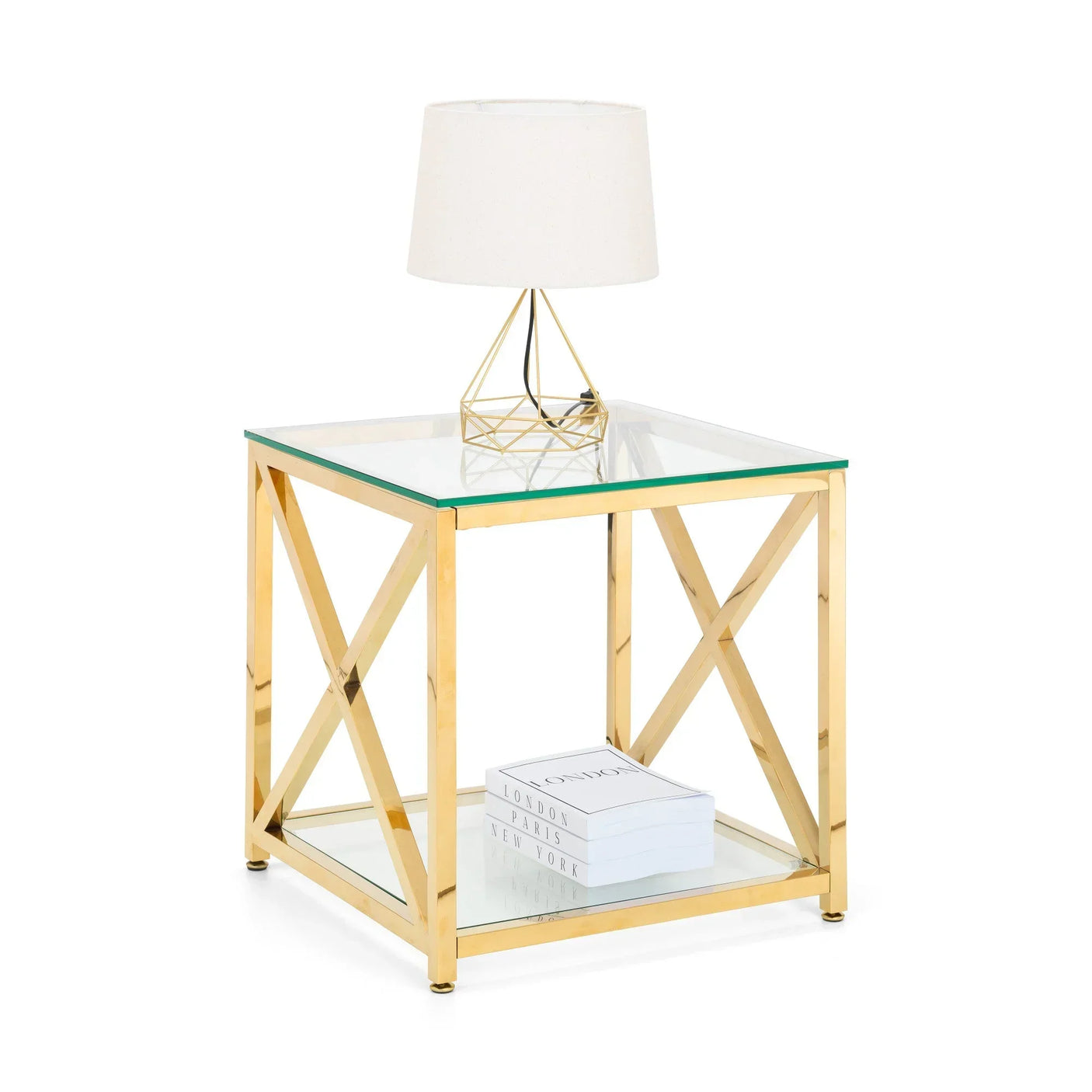 Gold frame glass side table with white lamp and stacked books on lower shelf