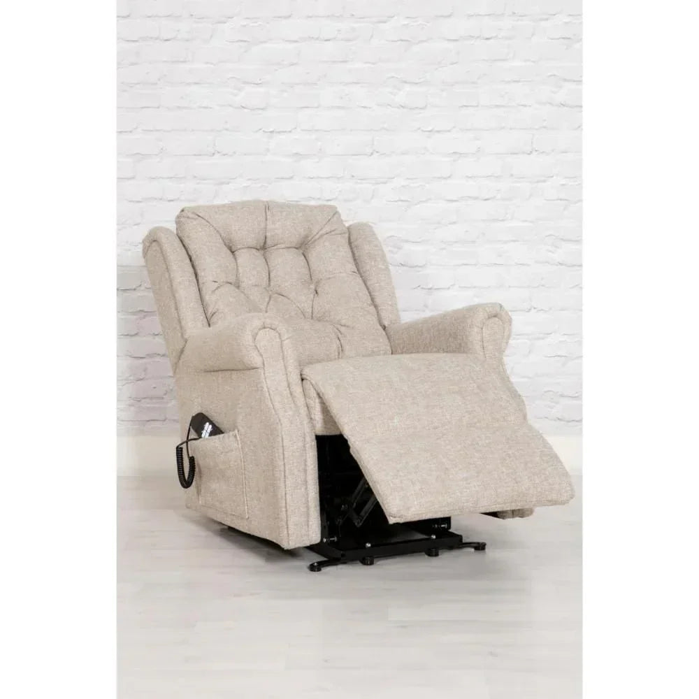 Beige fabric recliner chair with footrest extended on wooden floor in front of brick wall
