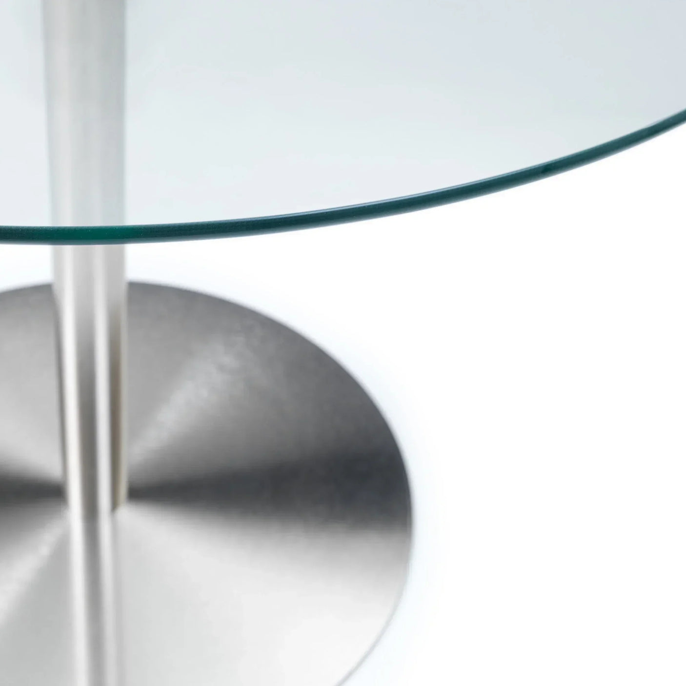 Round glass dining table with brushed stainless steel pedestal base, close-up view