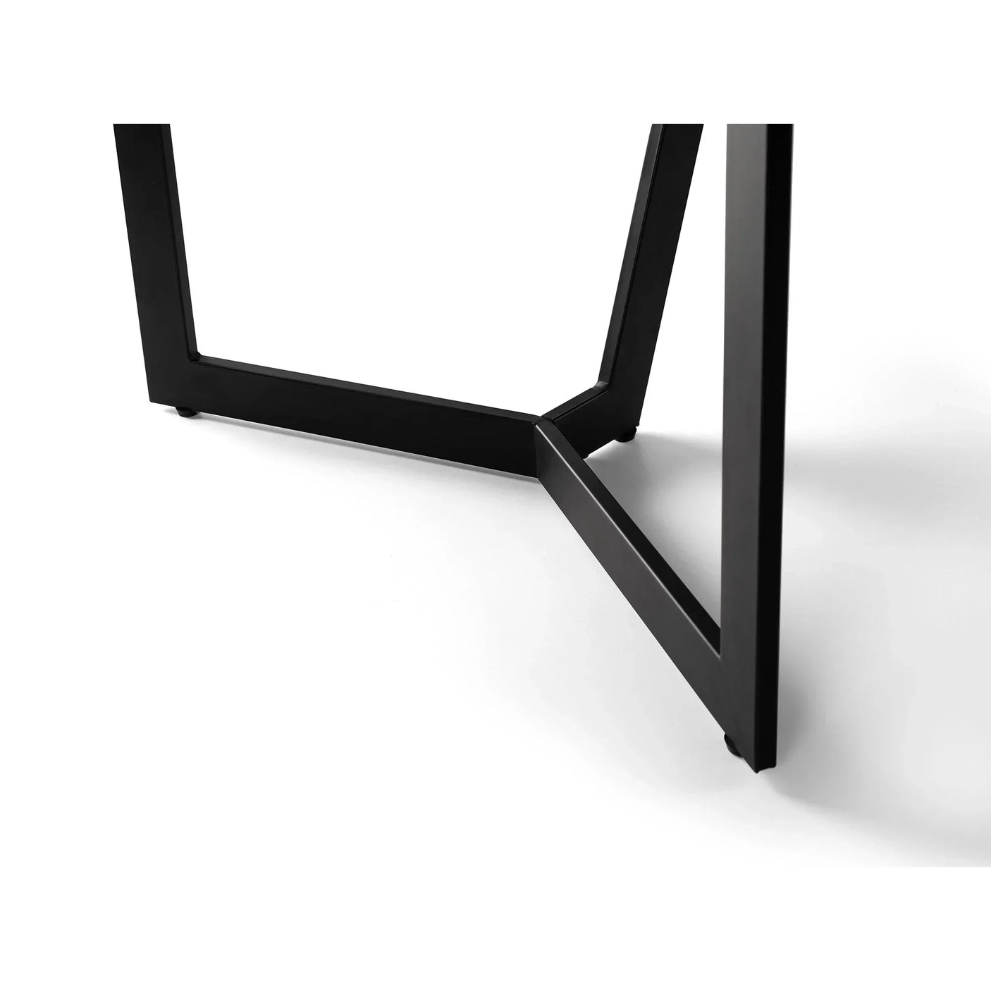 Black metal dining table leg detail with geometric design on white background