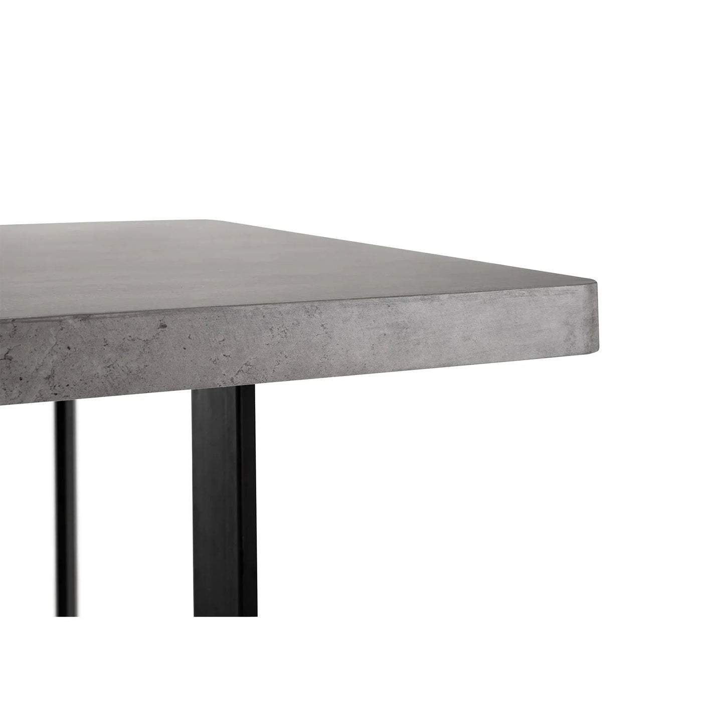 Concrete effect dining table corner with thick tabletop and black metal legs