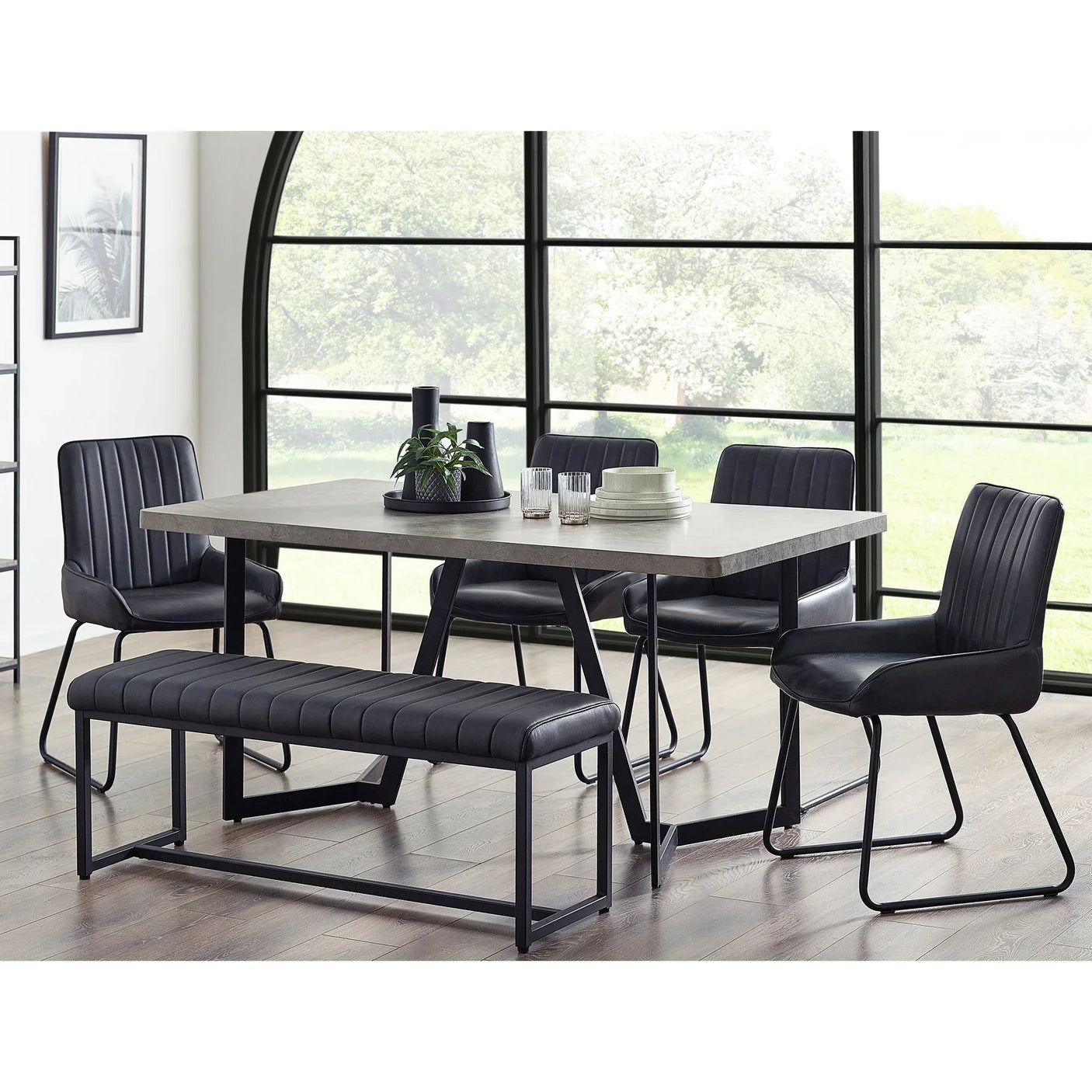 Concrete effect dining table with black faux leather bench and chairs in modern dining room