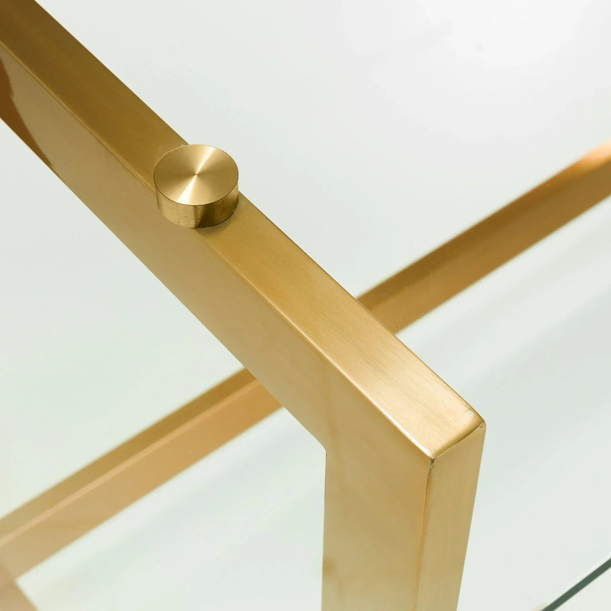 Close-up of glass top coffee table with gold metal frame and corner detail