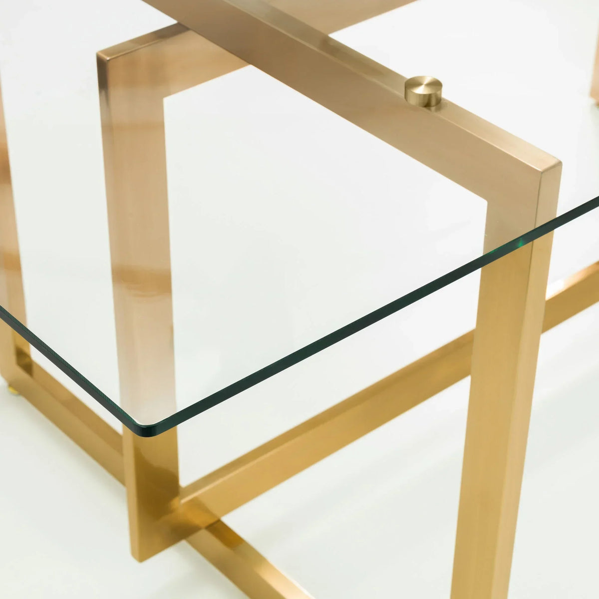 Glass coffee table with gold metal frame corner and geometric leg detail