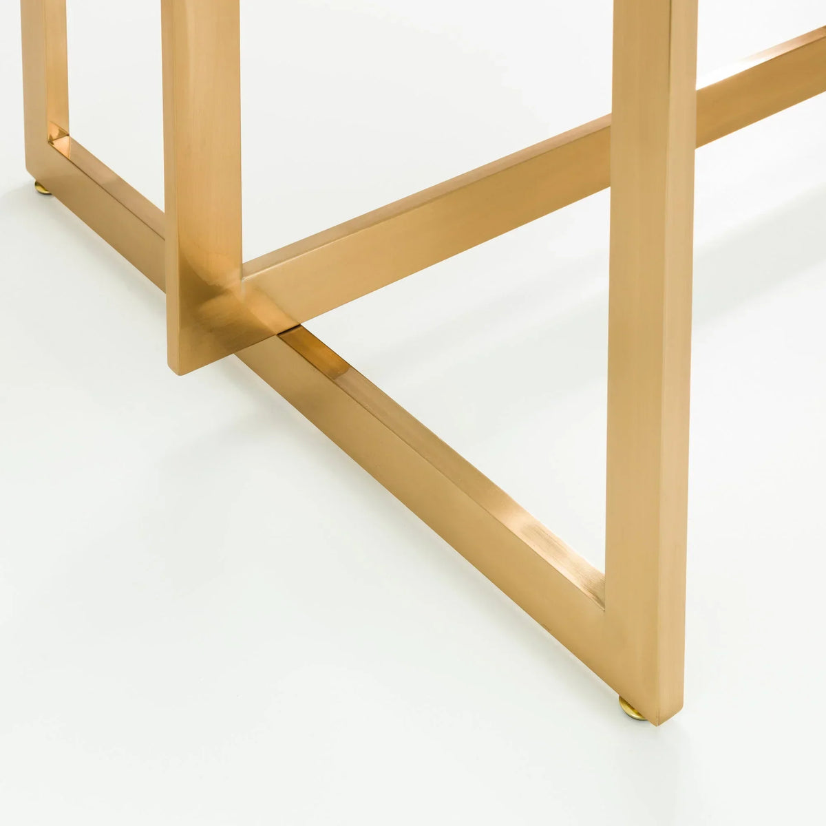 Gold metal table legs with crossbar detail on white background