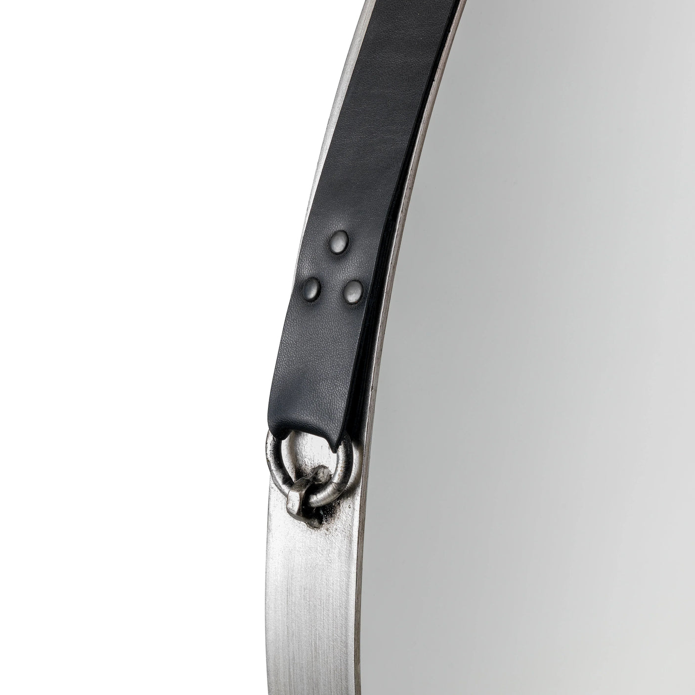 Round wall mirror with metal frame and black leather hanging strap detail close-up