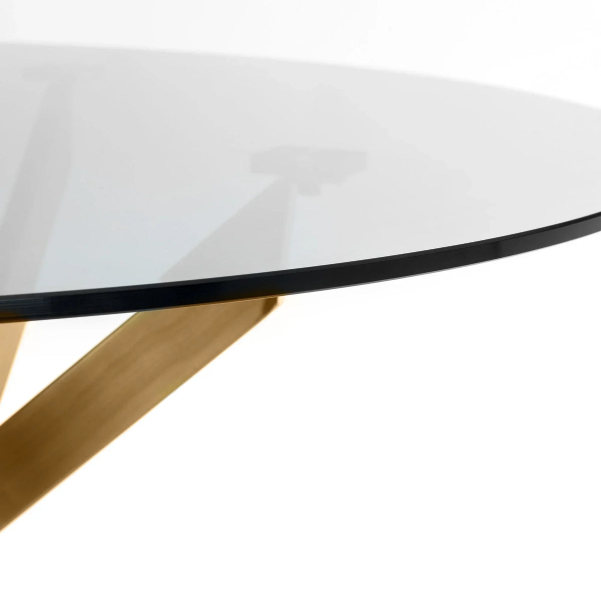 Round glass dining table with gold metal legs, close view of tabletop edge and base
